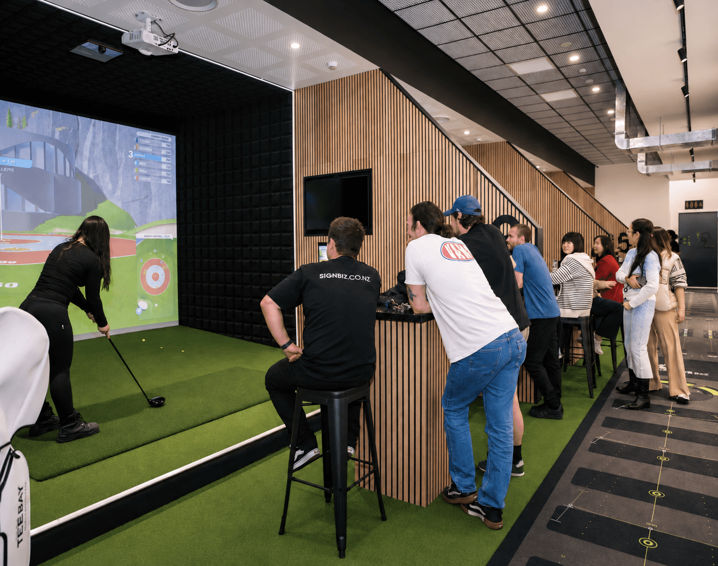 Guests enjoying indoor golf at The Tee Bay in Botany, East Auckland